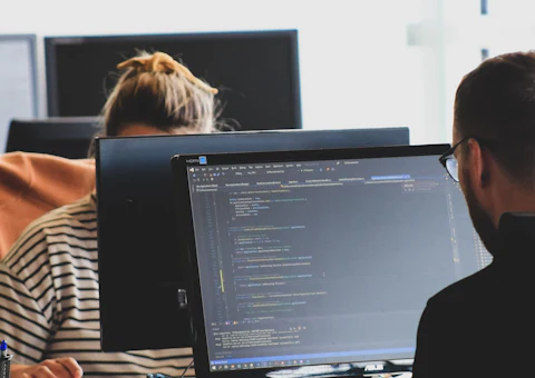 Two engineers reviewing code together in an office
